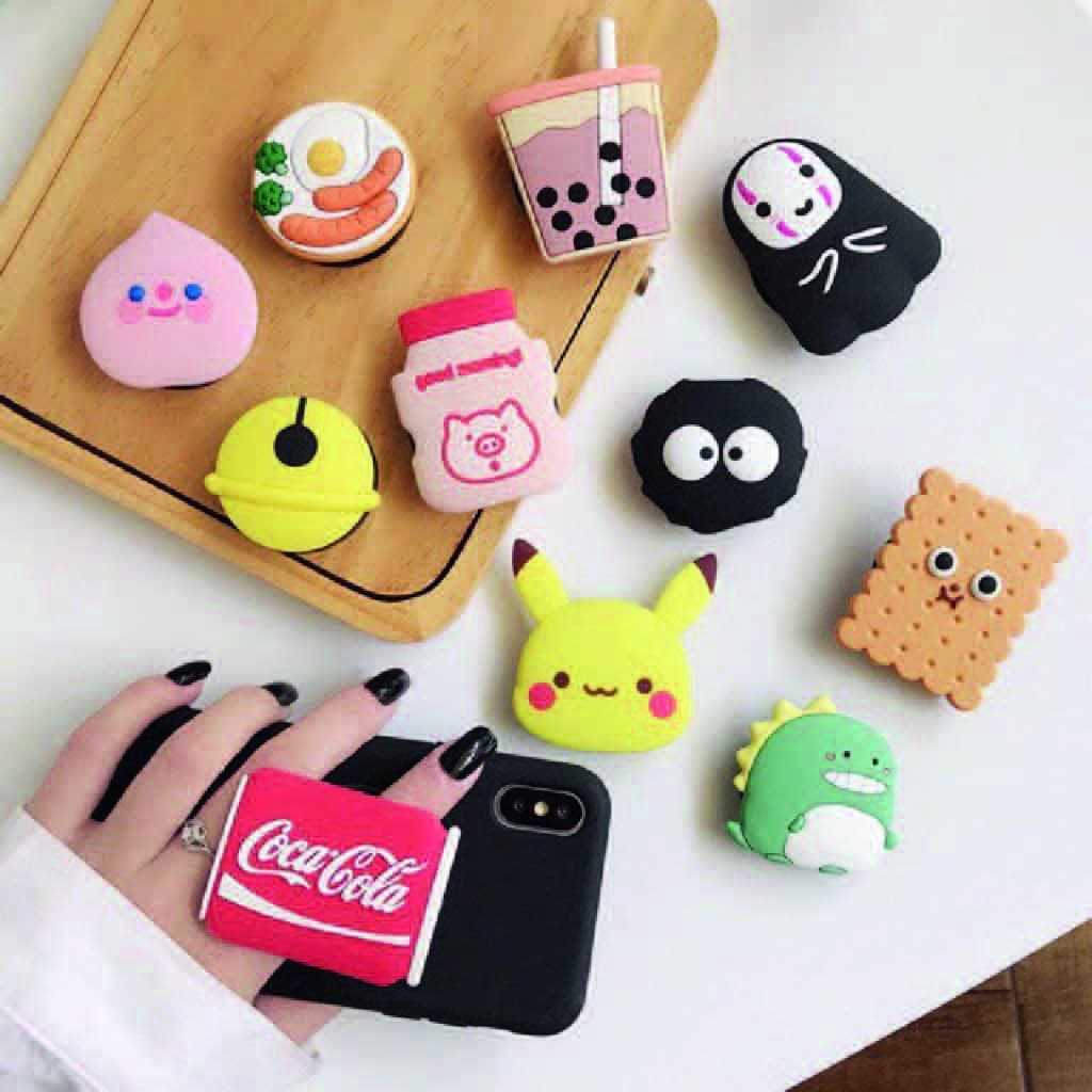 Pop socket de Fomo Argentina - Los Pop Sockets son accesorios pequeños y retráctiles que se adhieren a la parte trasera de un teléfono o funda. Están diseñados para brindar mejor agarre, soporte y funcionalidad al dispositivo.¿Qué son? Un Pop Socket es un botón redondo con una base adhesiva y una estructura que se expande y contrae. Pueden tener diseños decorativos y se fabrican en varios colores y estilos. ¿Para qué sirven? Mejor agarre: Evitan que el teléfono se caiga, especialmente al usarlo con una sola mano.
 Soporte: Funcionan como un soporte para apoyar el teléfono en superficies planas (modo horizontal o vertical). Comodidad: Facilitan tomar selfies, grabar videos o enviar mensajes. 
 Enrollar auriculares: Algunos modelos permiten enrollar el cable alrededor del soporte ¿Cómo se usan? Pega el Pop Socket en la parte trasera del teléfono o funda, en una posición cómoda para tu mano, tira hacia afuera para expandirlo, usa tu dedo (generalmente índice o medio) entre el teléfono y el Pop Socket para sostenerlo, presiona hacia adentro para cerrarlo cuando no lo uses. Puedes también inclinarlo ligeramente para usarlo como soporte. Es reutilizable y algunos modelos permiten cambiar el disco decorativo o moverlo de posición.